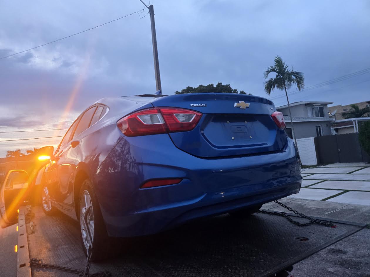 Rear view of blue Chevrolet Cruze secured on a flatbed