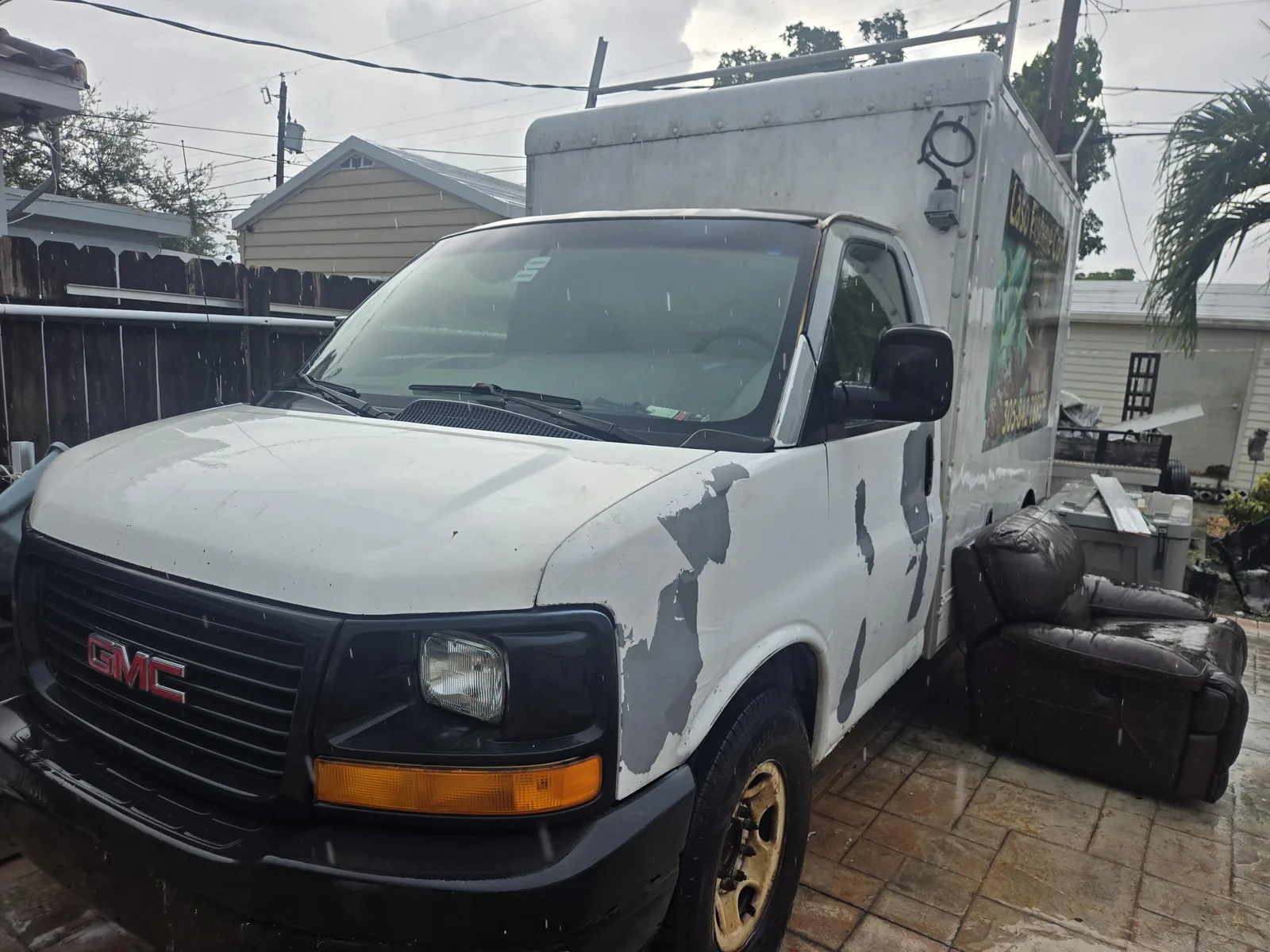 Used white GMC commercial work van available for junk car evaluation and pickup in Doral