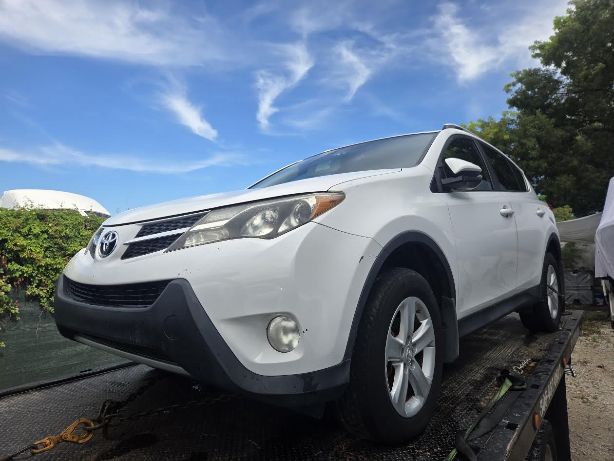 White damaged Toyota RAV4 secured for flatbed transport