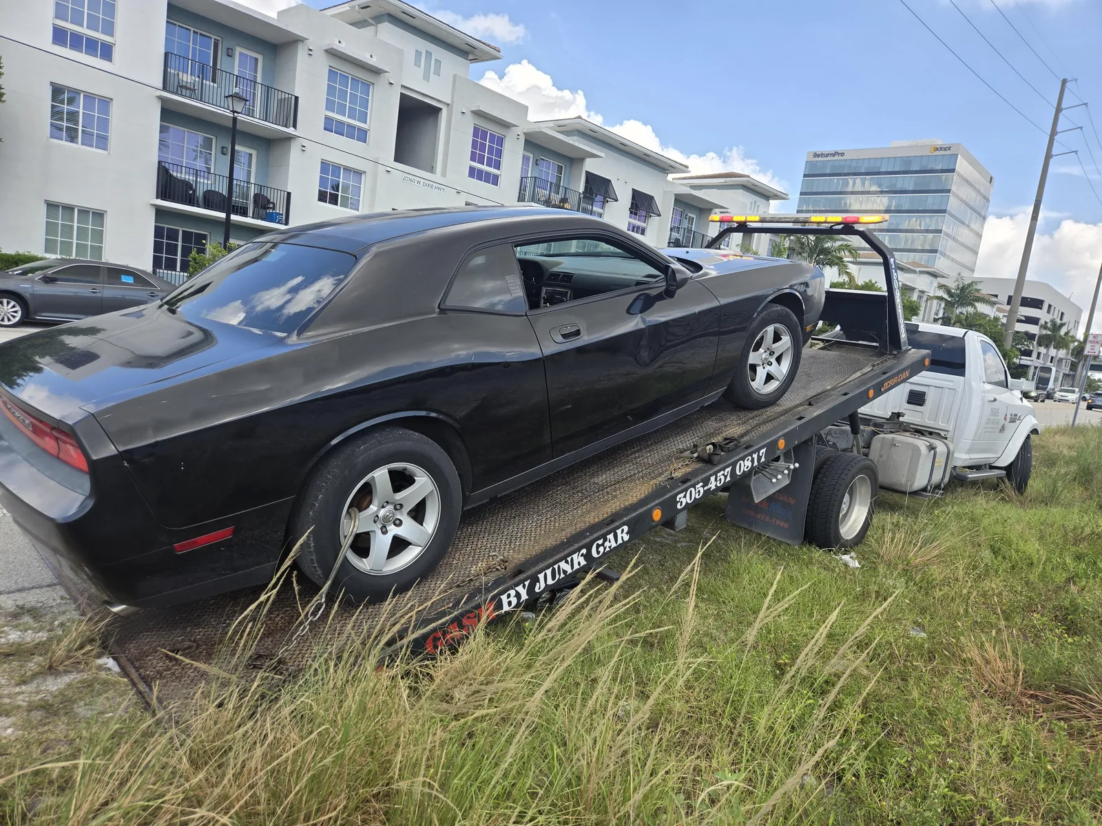 Cash 4 Junk Cars Miami flatbed tow truck carrying a black Dodge Challenger with phone 305-457-0817 visible