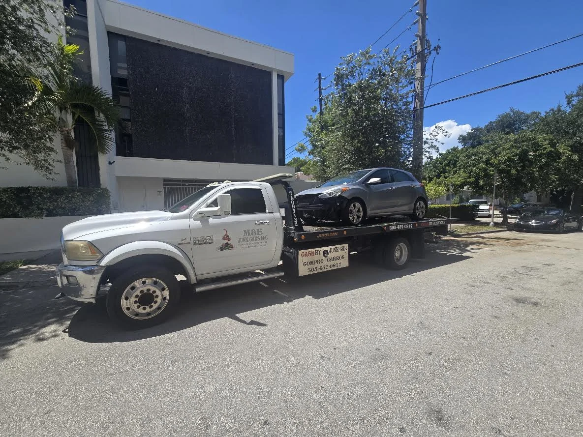 Cash 4 Junk Cars Miami flatbed truck transporting a gray damaged car