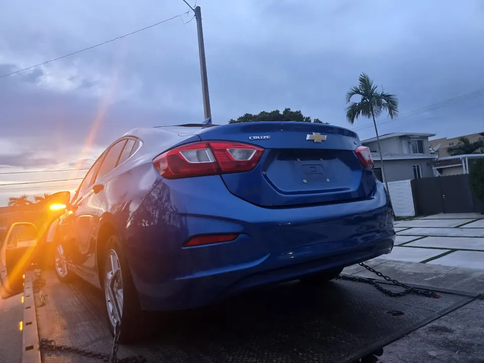 Rear view of blue Chevrolet Cruze secured on a flatbed